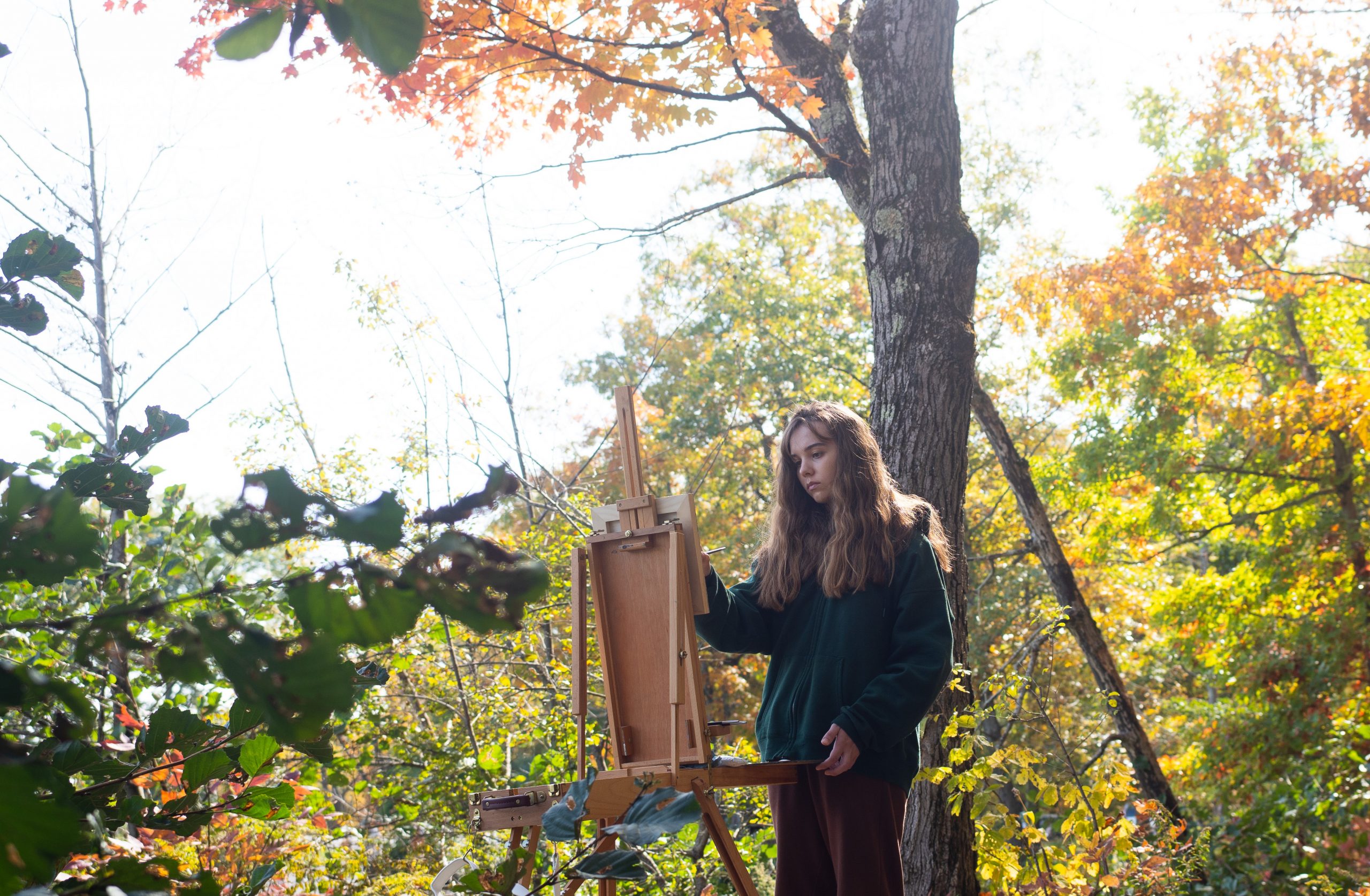 girl painting woods leaves easel